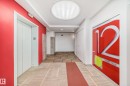 Modern hallway featuring a bright red accent wall and neutral patterned carpeting - 1207 10024 Jasper Avenue, Edmonton, AB  - Indoor Photo Showing Other Room 