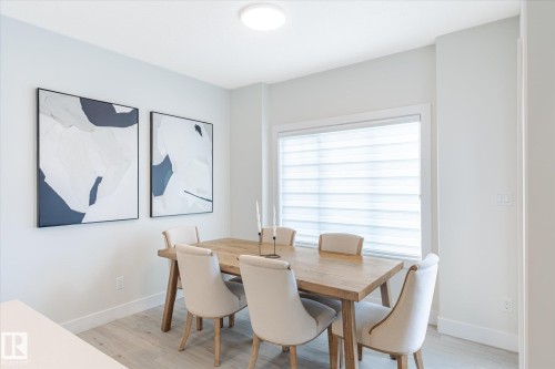 Dining area featuring light wood-finish flooring and a rectangular window with horizontal blinds - 1214 Eaton Lane, Edmonton, AB - Indoor Photo Showing Dining Room