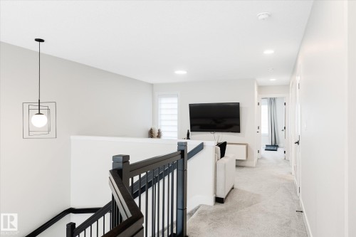 Upper-level landing featuring light gray carpet flooring and white walls - 1214 Eaton Lane, Edmonton, AB - Indoor Photo Showing Other Room