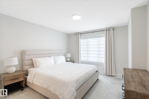 Bedroom featuring light gray walls, plush gray carpeting, a large window with white blinds, and ceiling-mounted lighting - 1214 Eaton Lane, Edmonton, AB - Indoor Photo Showing Bedroom