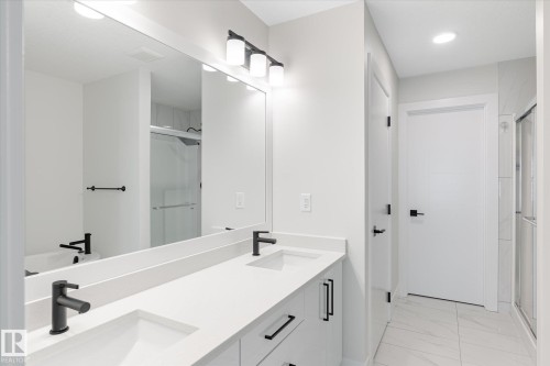 Double vanity with integrated sinks, matte black fixtures, and a spacious countertop - 1214 Eaton Lane, Edmonton, AB - Indoor Photo Showing Bathroom