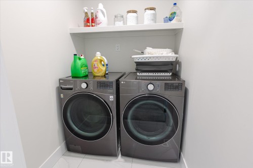 Integrated laundry area with front-loading washer and dryer units - 1214 Eaton Lane, Edmonton, AB - Indoor Photo Showing Laundry Room