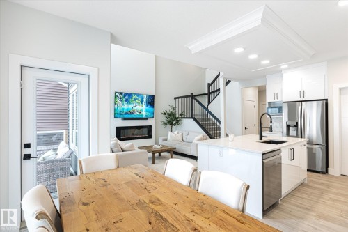 Modern kitchen with white cabinetry, stainless steel appliances, and a central island with a quartz countertop - 1214 Eaton Lane, Edmonton, AB - Indoor