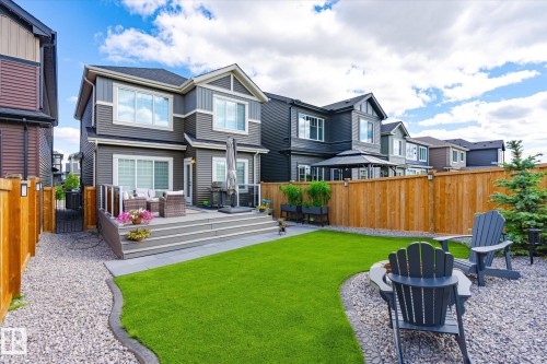 Expansive backyard featuring a multi-level composite deck, manicured lawn, gravel patio, and privacy fencing - 1214 Eaton Lane, Edmonton, AB - Outdoor With Deck Patio Veranda