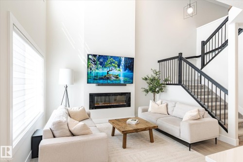 Soaring ceilings highlight the contemporary fireplace and media wall - 1214 Eaton Lane, Edmonton, AB - Indoor Photo Showing Living Room With Fireplace