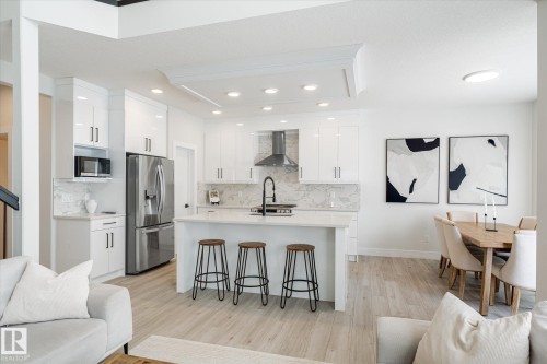 Open-concept kitchen and dining area featuring light wood-finish flooring - 1214 Eaton Lane, Edmonton, AB - Indoor Photo Showing Kitchen With Upgraded Kitchen