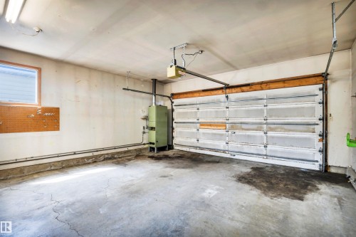 Attached garage space featuring a segmented overhead door, concrete flooring, and a built-in furnace unit - 6723 39 Avenue, Edmonton, AB - Indoor Photo Showing Garage