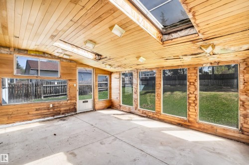 Sunroom with wood-paneled walls and ceiling, concrete flooring, and multiple windows providing natural light - 6723 39 Avenue, Edmonton, AB -  With Exterior