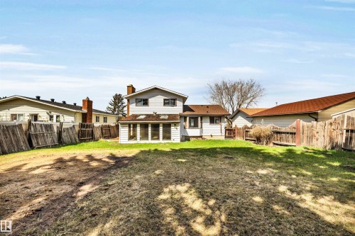 Expansive backyard featuring a partial grass lawn, privacy fencing, and a two-story residence with a sunroom addition - 6723 39 Avenue, Edmonton, AB - Outdoor