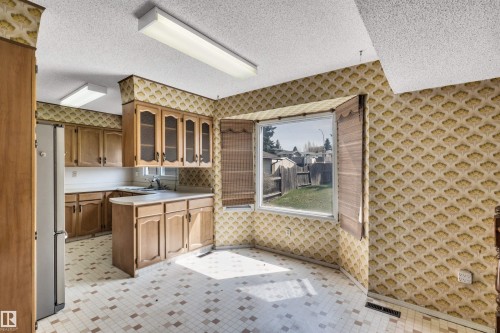 Kitchen with light wood-finish cabinetry, white countertops, and patterned wallpaper - 6723 39 Avenue, Edmonton, AB - Outdoor With Exterior