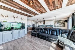 Open concept living space featuring wood-finish flooring and a decorative wood plank ceiling treatment - 