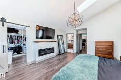 Vaulted ceiling bedroom with wood-finish flooring - 