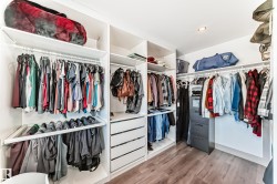 Custom closet system featuring multiple hanging rods, integrated shelving, and built-in drawer storage - 