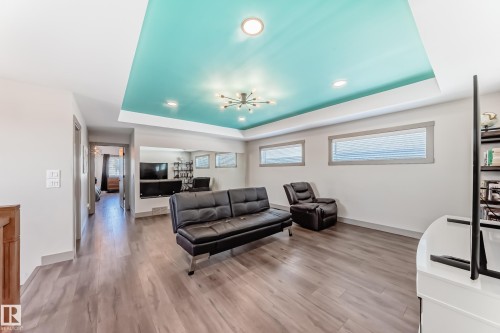 Recessed ceiling with an accent color, wood-finish flooring, and built-in shelving - 5263 47 Ave, Calmar, AB - Indoor