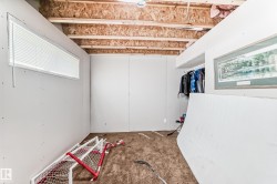 Unfinished room featuring exposed ceiling joists and particle board subfloor - 