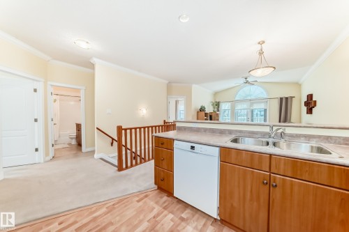 Kitchen counter featuring a dual stainless steel sink and a white dishwasher - 40 13808 155 Avenue, Edmonton, AB - Indoor Photo Showing Kitchen With Double Sink