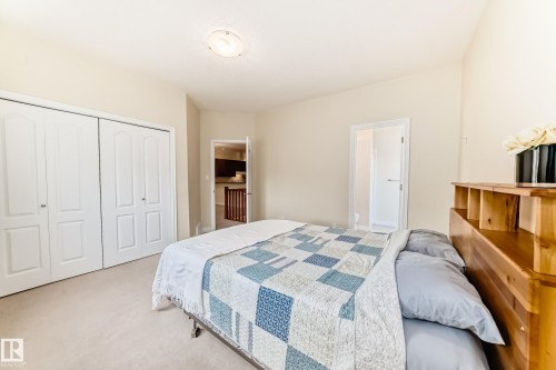 Carpeted room featuring a double bi-fold closet with panel doors and a flush-mount ceiling light fixture - 40 13808 155 Avenue, Edmonton, AB - Indoor Photo Showing Bedroom