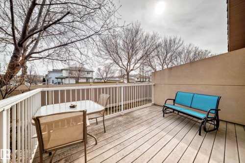 Outdoor decking area featuring wood-finish flooring, white railing, and a privacy wall - 40 13808 155 Avenue, Edmonton, AB - Outdoor With Deck Patio Veranda