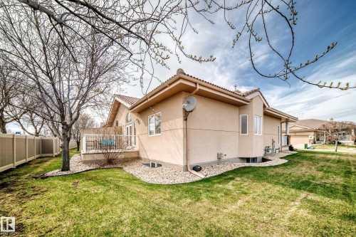 Stucco exterior featuring a tile roof and a private deck with white railing - 40 13808 155 Avenue, Edmonton, AB - Outdoor