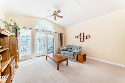 Living area with vaulted ceiling, arched transom window, ceiling fan, and patio door with sidelight windows - 40 13808 155 Avenue, Edmonton, AB - Indoor