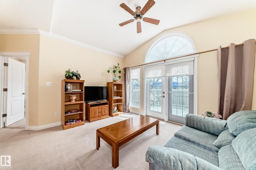 Living area featuring a vaulted ceiling with a ceiling fan, crown molding, and light-colored carpeting - 40 13808 155 Avenue, Edmonton, AB - Indoor Photo Showing Living Room