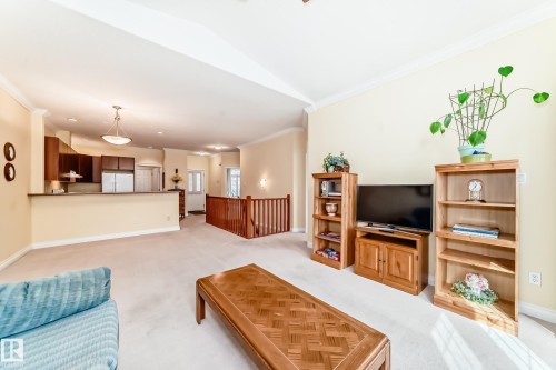 Open-concept living area featuring light-toned carpeting and neutral wall tones - 40 13808 155 Avenue, Edmonton, AB - Indoor Photo Showing Living Room