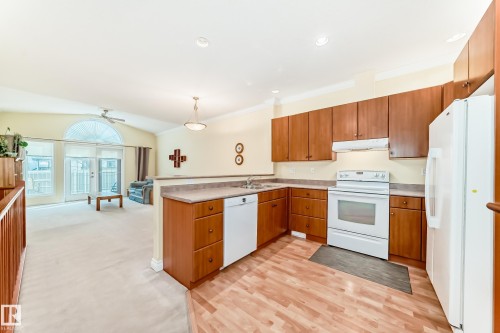 Kitchen featuring wood-finish cabinetry and light-toned countertops - 40 13808 155 Avenue, Edmonton, AB - Indoor Photo Showing Kitchen