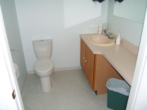 Bathroom featuring a vanity with an integrated sink, laminate countertop, and wood-finish cabinetry - 4707 50 Street, Two Hills, AB - Indoor Photo Showing Bathroom
