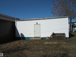 White vinyl-sided exterior building with a flat roof - 