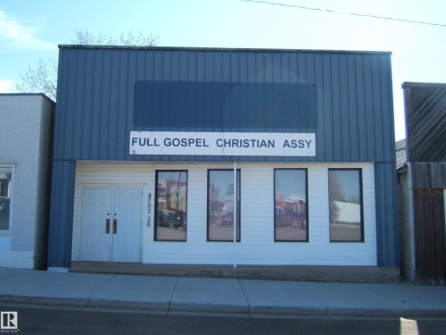 Commercial building featuring a blue corrugated metal facade over a white lower level - 4707 50 Street, Two Hills, AB - Outdoor