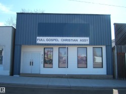 Commercial building featuring a blue corrugated metal facade over a white lower level - 