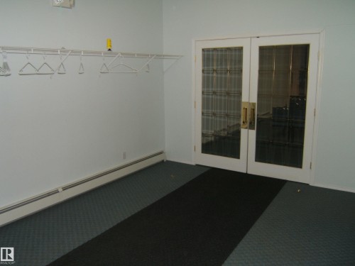Double glass-paneled doors with brass hardware - 4707 50 Street, Two Hills, AB - Indoor Photo Showing Other Room