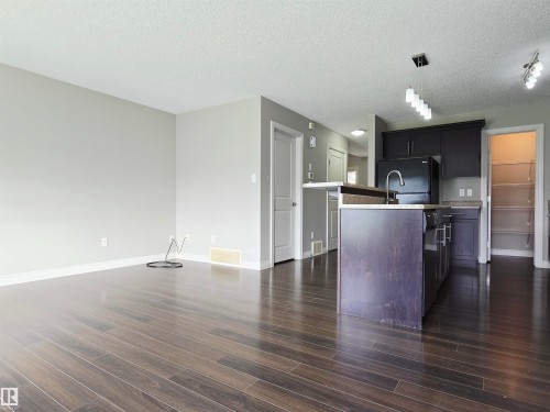 Open-concept living area featuring laminate flooring, light gray wall tones, and white trim - 21321 94 Avenue, Edmonton, AB - Indoor Photo Showing Kitchen