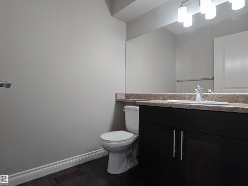 Bathroom featuring a dark wood-finish vanity with a light countertop, integrated sink, and chrome faucet - 21321 94 Avenue, Edmonton, AB - Indoor Photo Showing Bathroom
