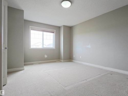 Carpeted room featuring a double-pane window with blinds, light gray wall paint, white trim, and a ceiling-mounted light fixture - 21321 94 Avenue, Edmonton, AB - Indoor Photo Showing Other Room