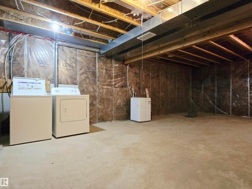 Unfinished basement with exposed ceiling joists and concrete flooring - 21321 94 Avenue, Edmonton, AB - Indoor Photo Showing Laundry Room