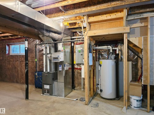 Utility room with concrete flooring, exposed ceiling joists, and a partial window - 21321 94 Avenue, Edmonton, AB - Indoor Photo Showing Basement