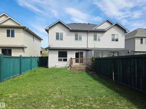 Spacious backyard with green fencing, a wooden deck, and a sliding glass door entry to the property - 21321 94 Avenue, Edmonton, AB - Outdoor