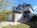 Two-story residence featuring gray siding with darker trim accents, an attached garage, and a covered front entry with stone veneer detailing - 21321 94 Avenue, Edmonton, AB  - Outdoor 