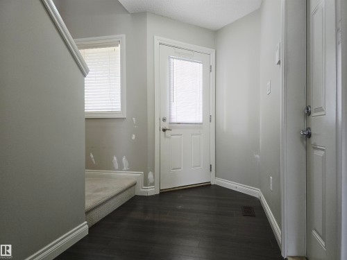 Entryway featuring dark laminate flooring, light gray walls, and white baseboards - 21321 94 Avenue, Edmonton, AB - Indoor Photo Showing Other Room