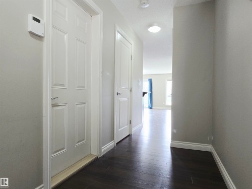 Entryway featuring dark laminate flooring, white panel doors, and neutral wall paint - 21321 94 Avenue, Edmonton, AB - Indoor Photo Showing Other Room