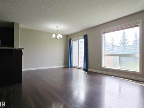 Spacious interior with dark laminate flooring, light neutral wall paint, and white trim - 21321 94 Avenue, Edmonton, AB - Indoor