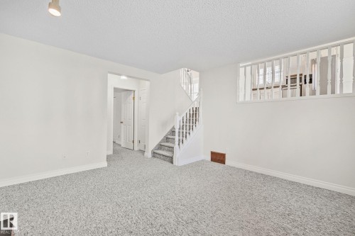 Spacious interior room with light gray carpet flooring and white painted walls - 18903 70 Avenue, Edmonton, AB - Indoor Photo Showing Other Room