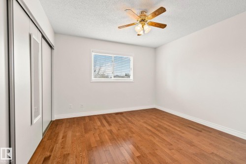Bright interior space featuring wood-finish flooring, a window with horizontal blinds, and a ceiling fan with integrated lighting - 18903 70 Avenue, Edmonton, AB - Indoor Photo Showing Other Room