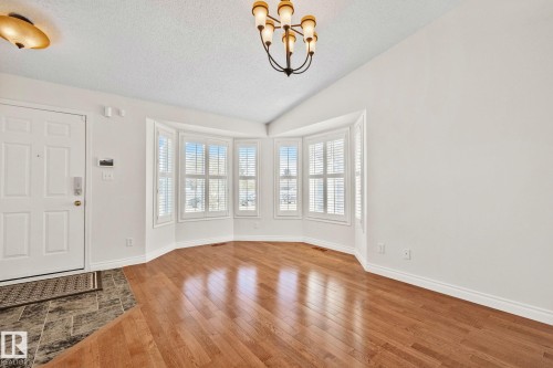 Bay window with multiple panels, wood-finish flooring, and a tiled entryway - 18903 70 Avenue, Edmonton, AB - Indoor Photo Showing Other Room