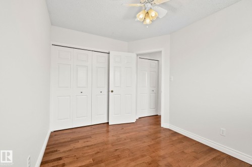 Bright interior room featuring wood-finish flooring, white walls, and white trim - 18903 70 Avenue, Edmonton, AB - Indoor Photo Showing Other Room