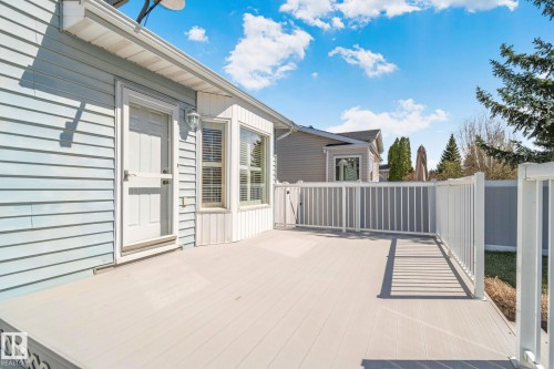 Expansive outdoor deck featuring light-colored composite decking, white railing, and a bay window - 18903 70 Avenue, Edmonton, AB - Outdoor