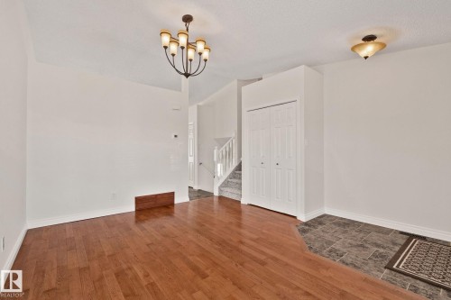Open room featuring wood-finish flooring and a tiled entryway - 18903 70 Avenue, Edmonton, AB - Indoor Photo Showing Other Room