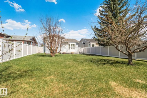 Expansive backyard featuring a green lawn, mature trees, and privacy fencing - 18903 70 Avenue, Edmonton, AB - Outdoor
