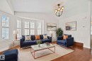 Living area featuring wood-finish flooring, a vaulted ceiling, and a bay window with plantation shutters - 18903 70 Avenue, Edmonton, AB  - Indoor Photo Showing Living Room 